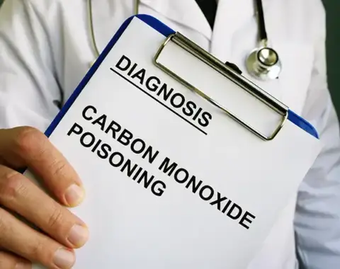 A doctor holding a chart that diagnoses a patient with carbon monoxide poisoning.